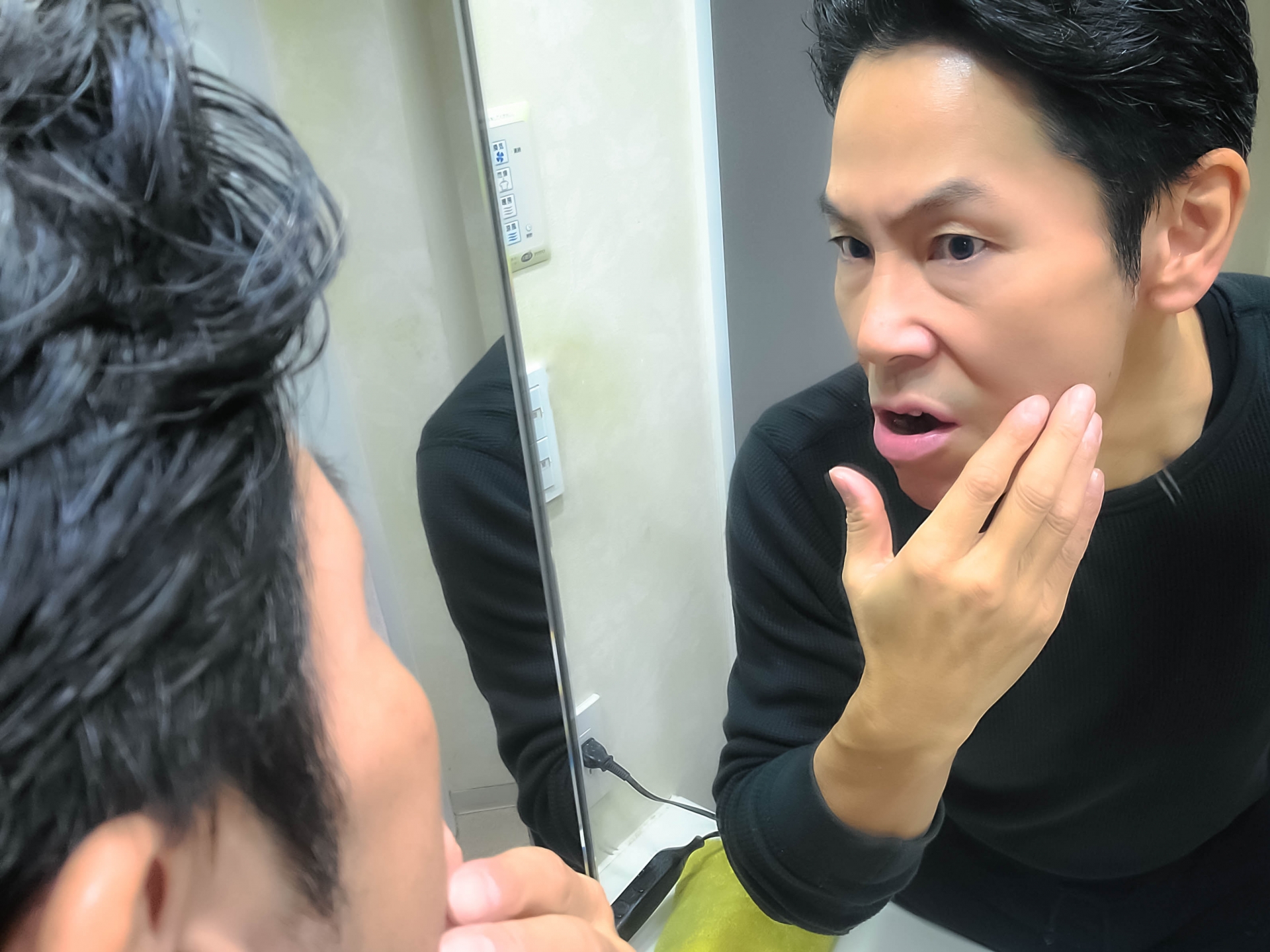鏡で顔まわりを確認する男性