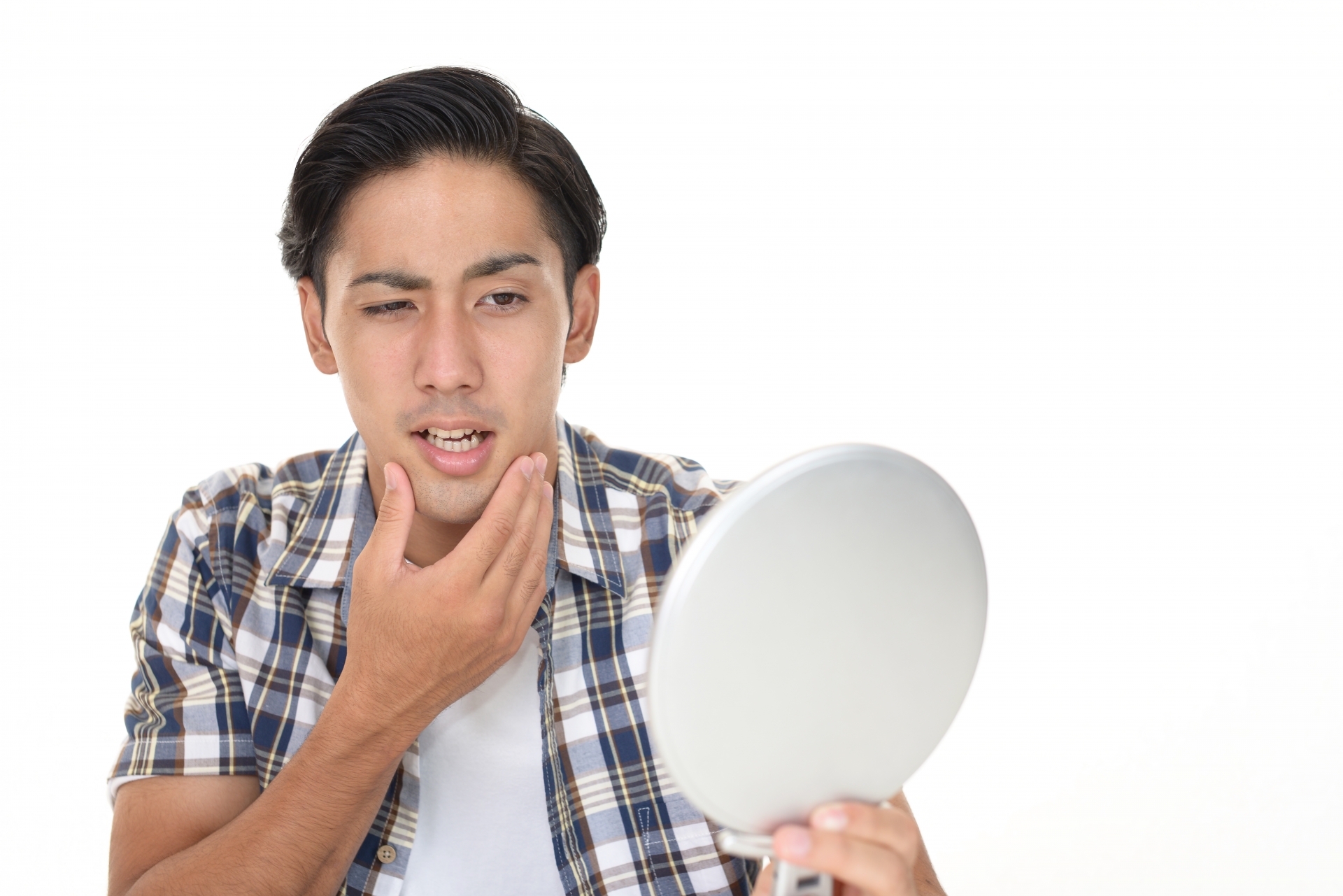 手鏡を見ながら悩む男性