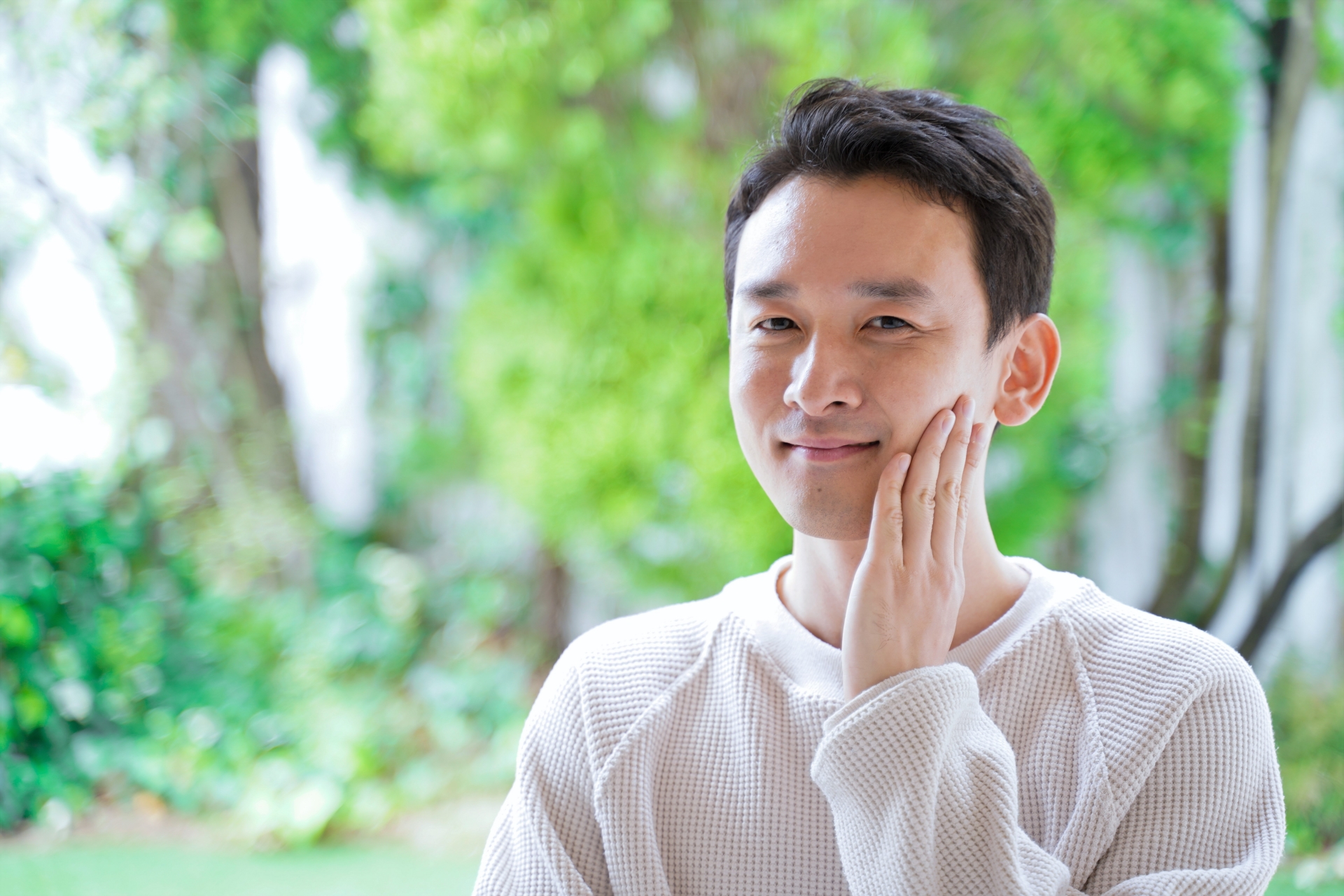 肌を整えて頬に触れる男性