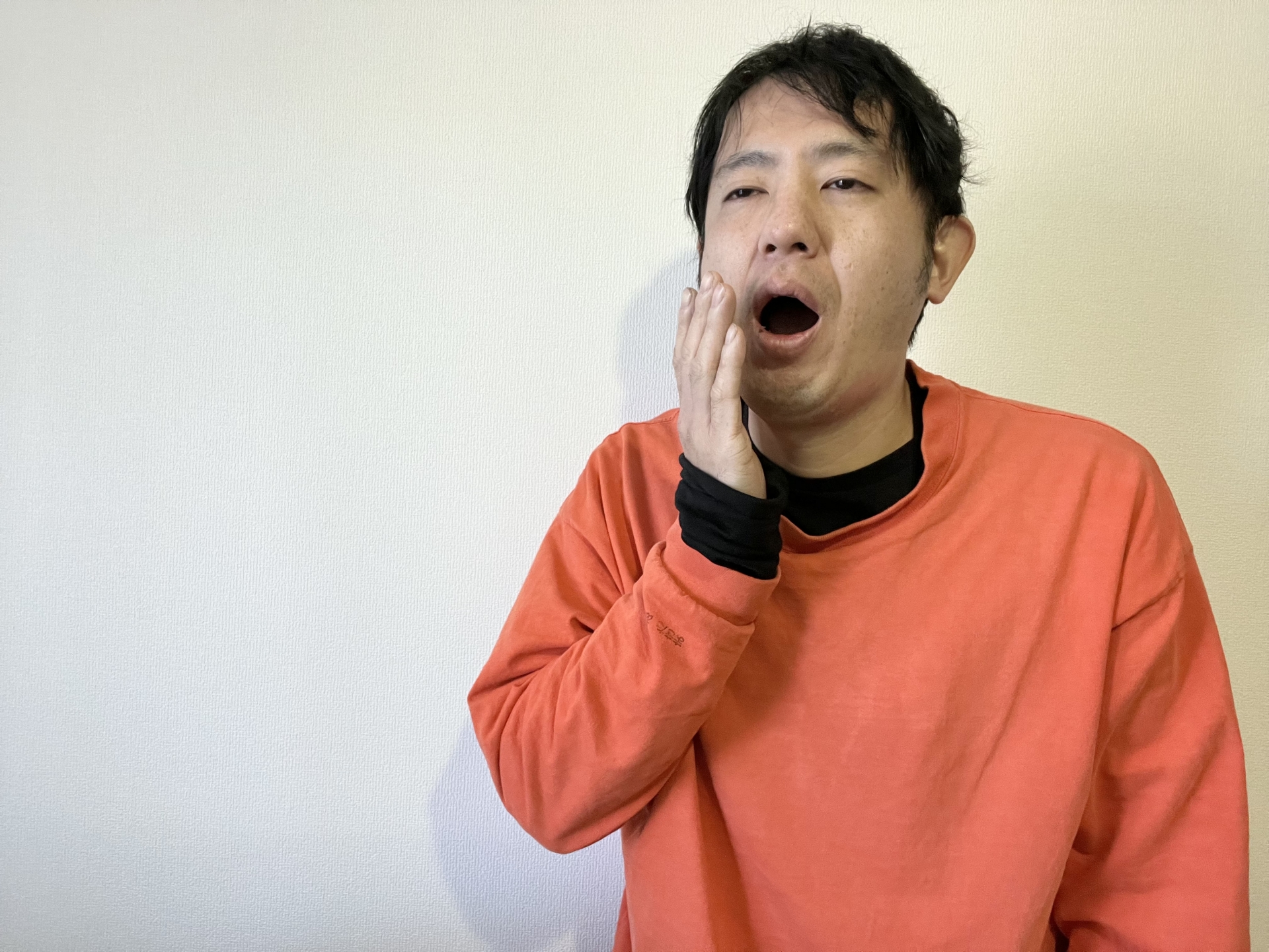 寝起きであくびをする男性