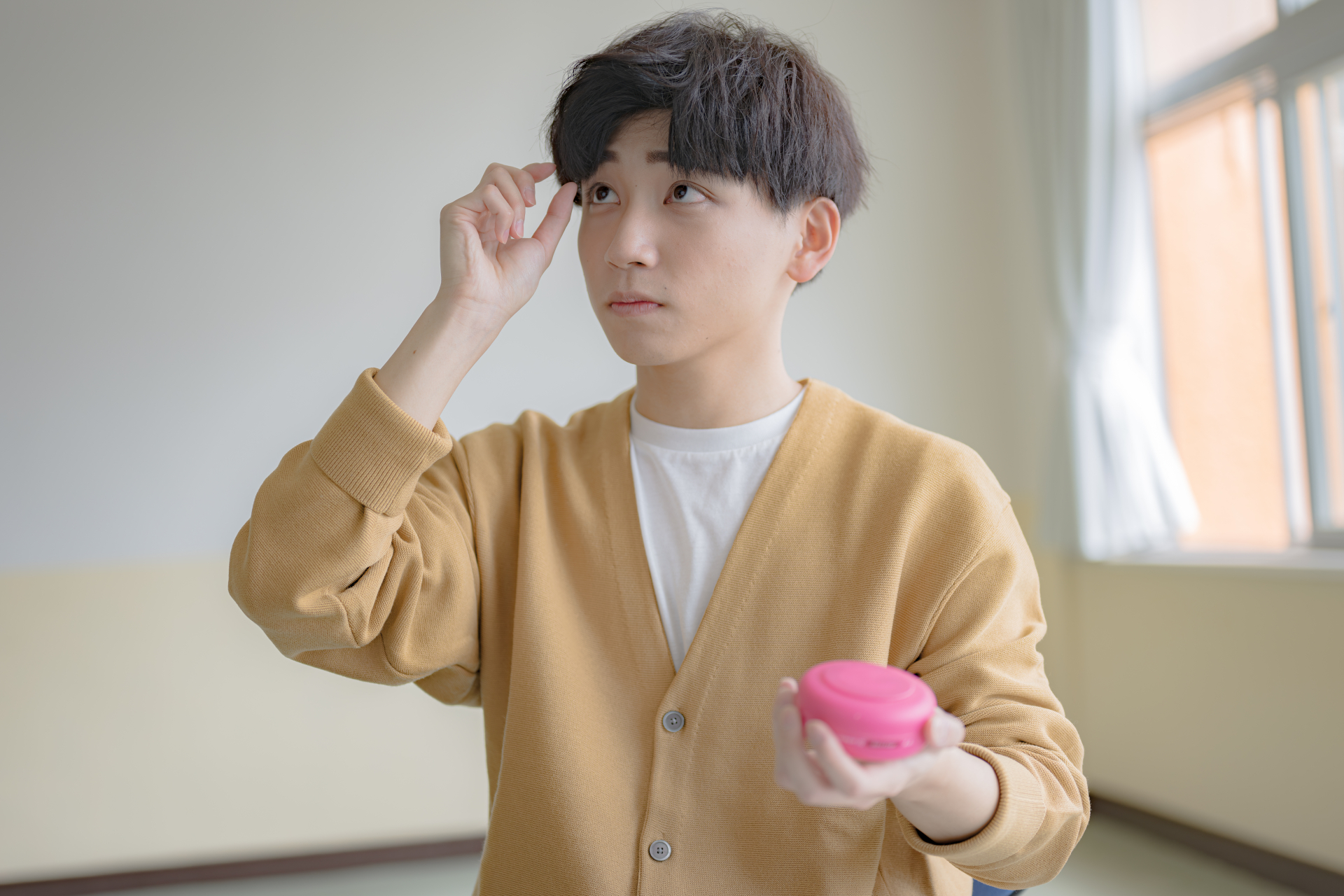 ヘアワックスで髪型を整える男性