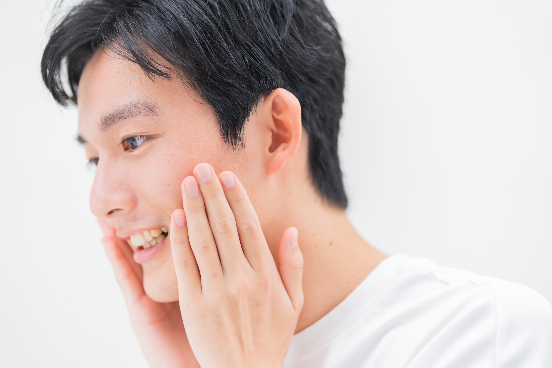 笑顔で頬に触れる男性